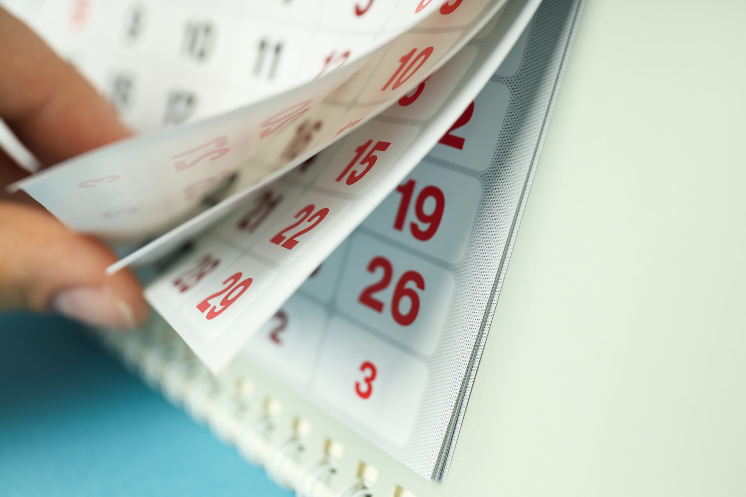 Person turning pages on calendar