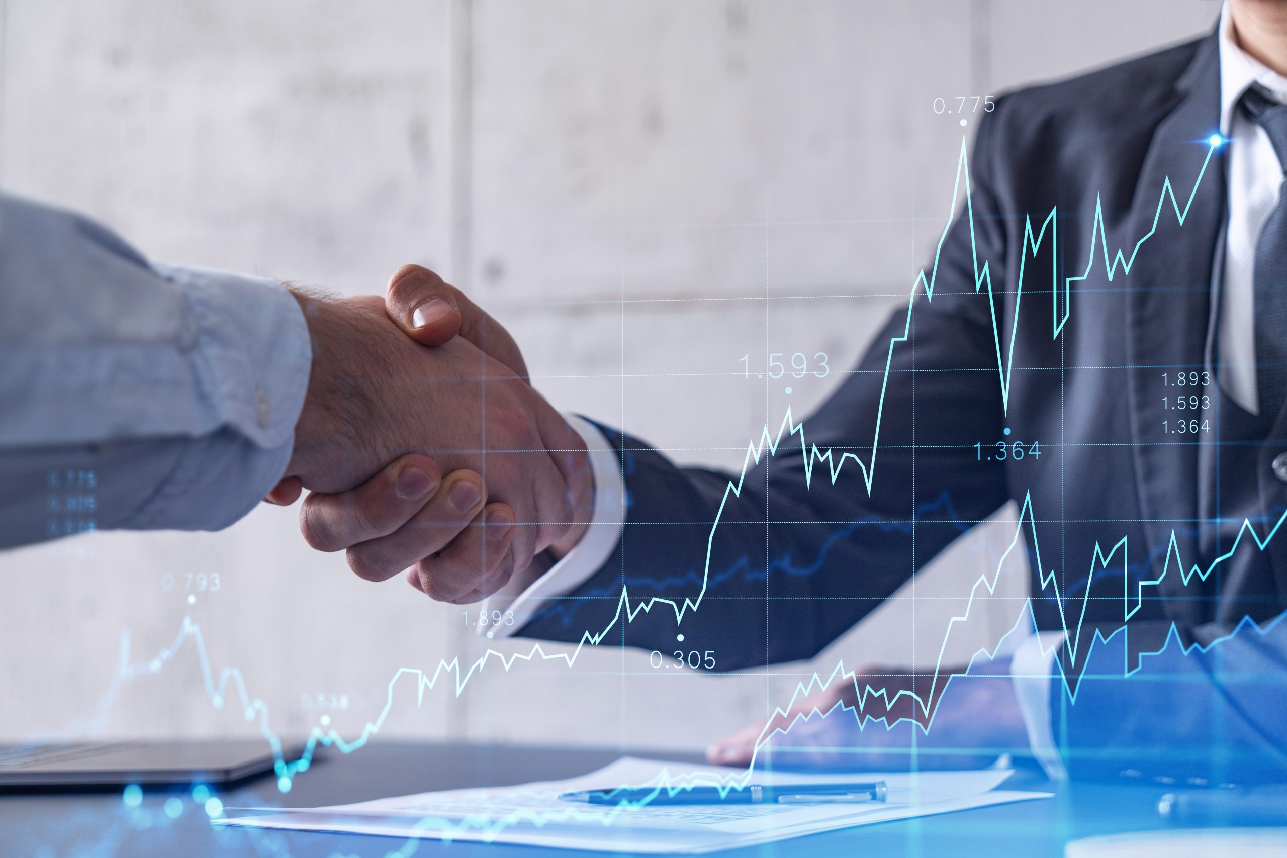 Investor shaking hands with business owner, also with a financial graph overlay in image