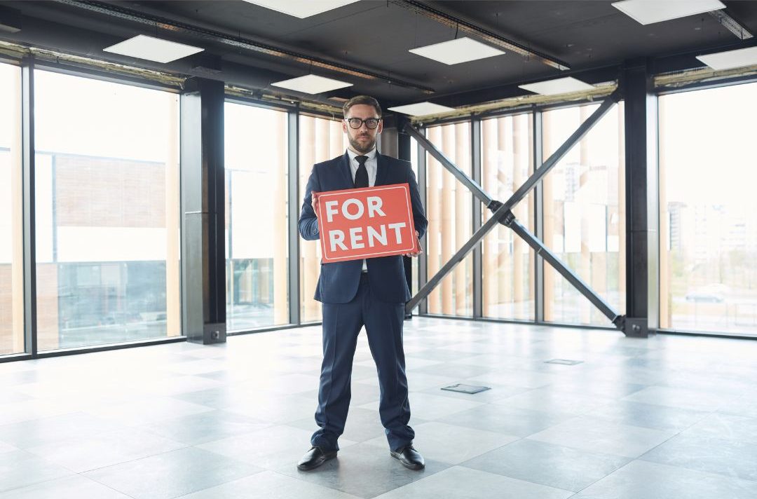 man showing for rent sign in a managed office